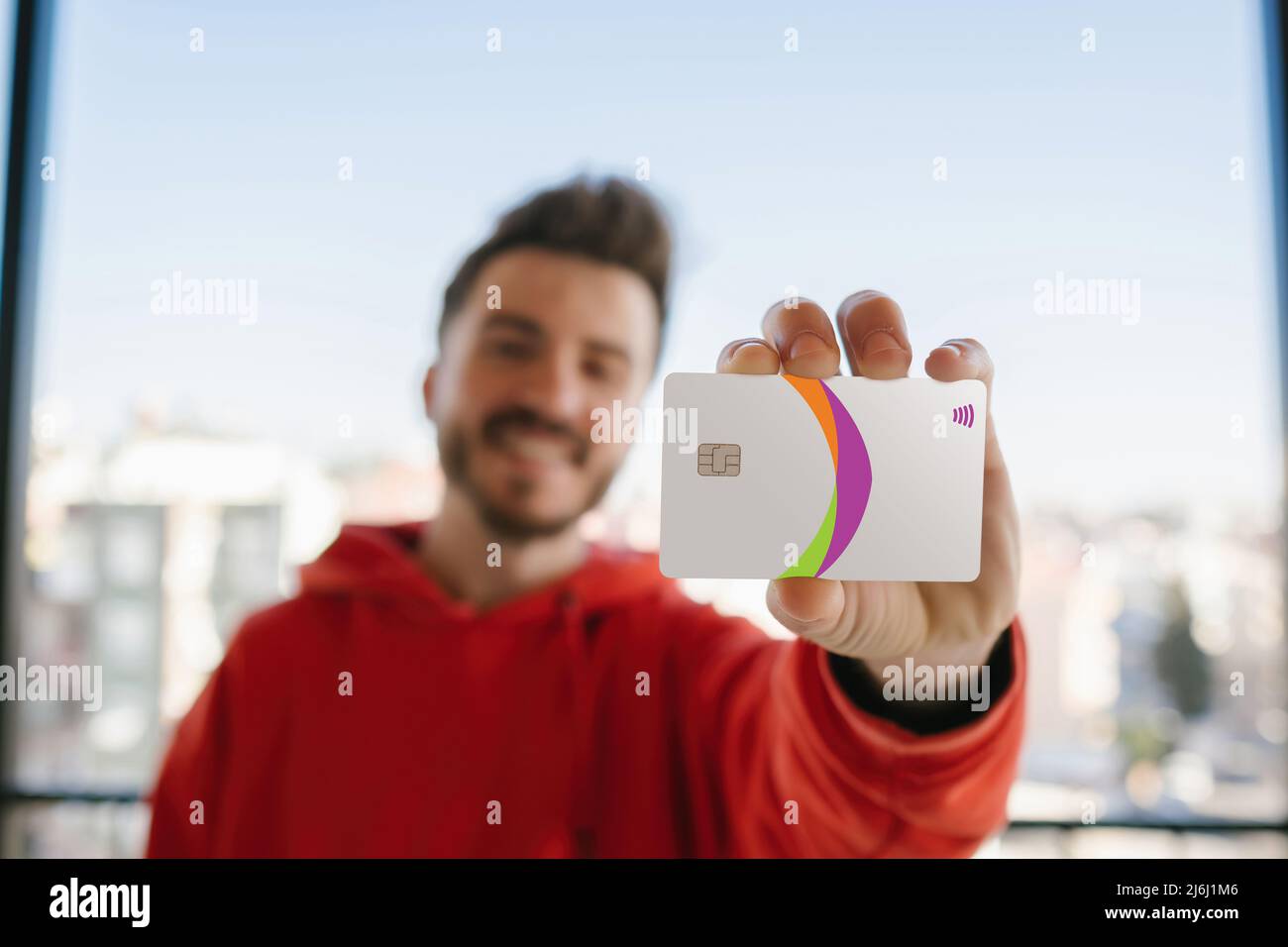 Kreditkarte, junger Mann, der vor der Kamera die Kreditkarte zeigte, glückliches Lächeln und sicheres Einkaufen im Internet Stockfoto