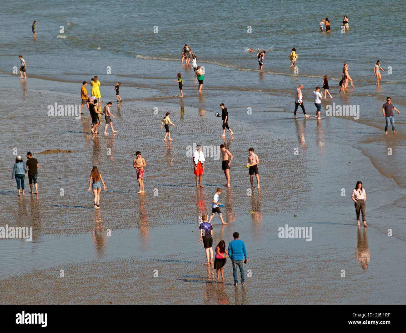 Menschen paddeln bei Ebbe am Strand von Brighton Stockfoto