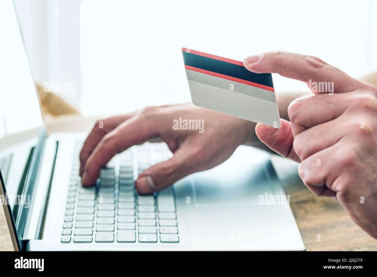 Person mit Kreditkarte und Laptop-Computer für Online-Shopping und Zahlung, E-Commerce-Konzept Stockfoto