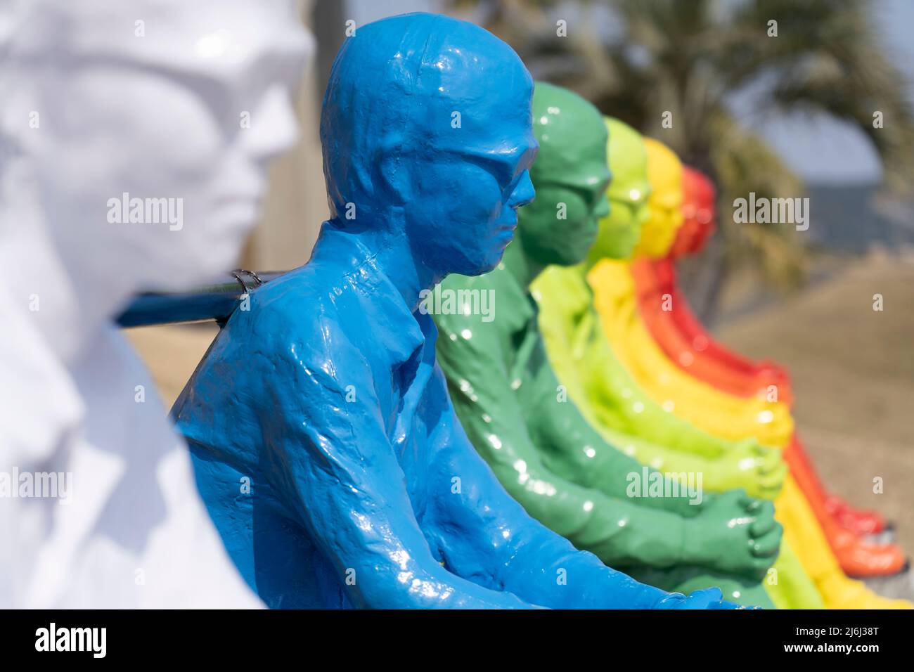 7 farbenfrohe Männerstatuen blicken auf den Ozean und die 7 Moai-Statuen in Sun Messe Nichinan, Miyazaki, Kyushu, Japan Stockfoto