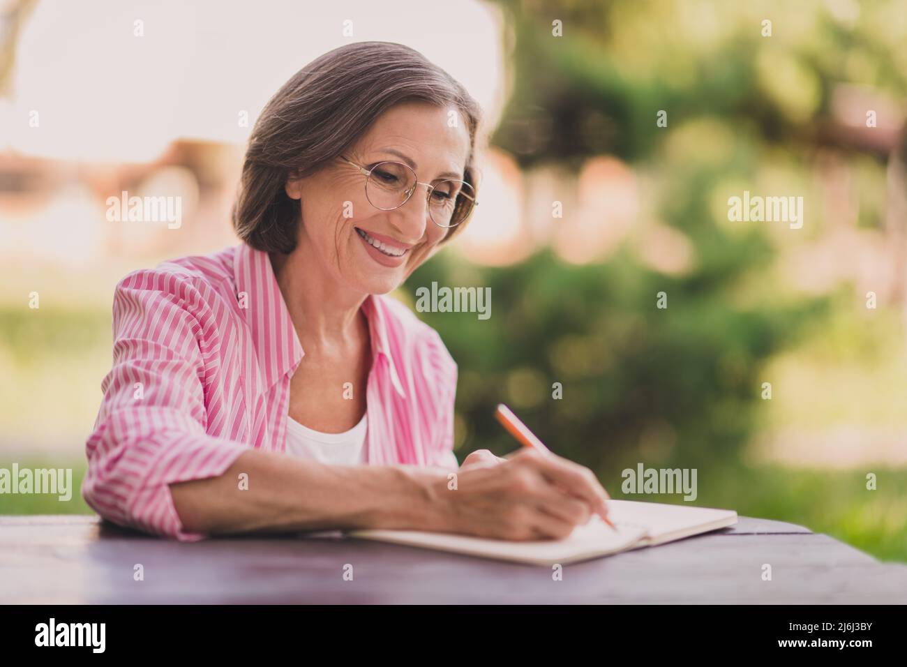 Porträt der positiven zufriedenen Person halten Stift schreiben Notizen Tagebuch Copybook Freizeit im Freien Stockfoto