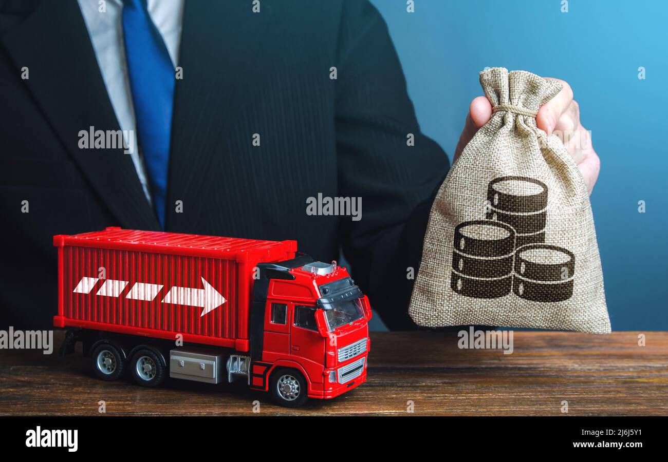 Geschäftsmann mit Geldbeutel und LKW. Hohe Einnahmen aus dem Transportgeschäft und dem Güterverkehr. Steigende Preise, weltweite Container-Knappheit CIS Stockfoto