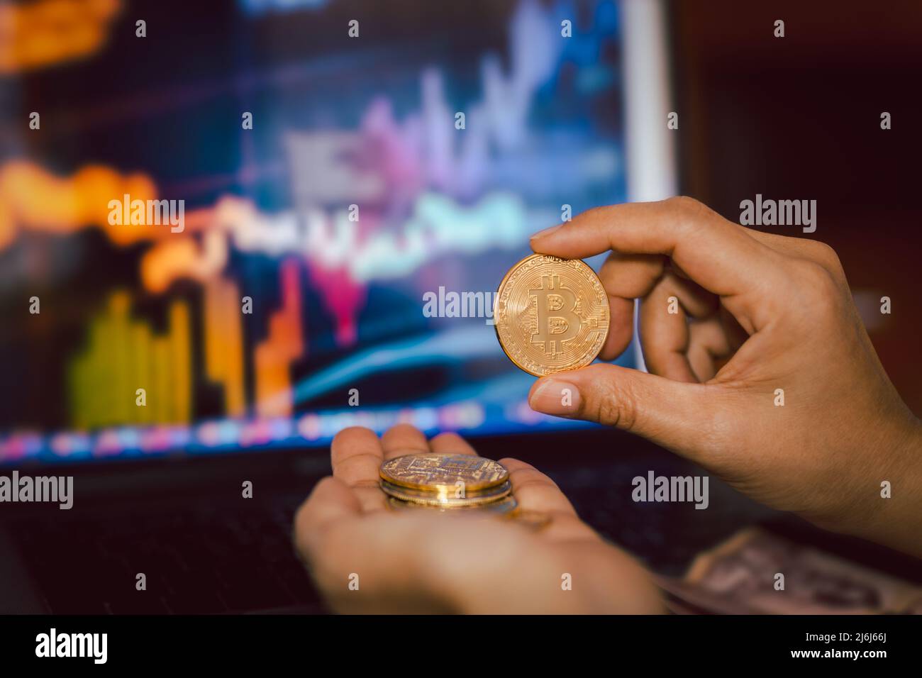 Geschäftsleute halten Bitcoin mit Computer-Trading-Chart im Hintergrund. Stockfoto