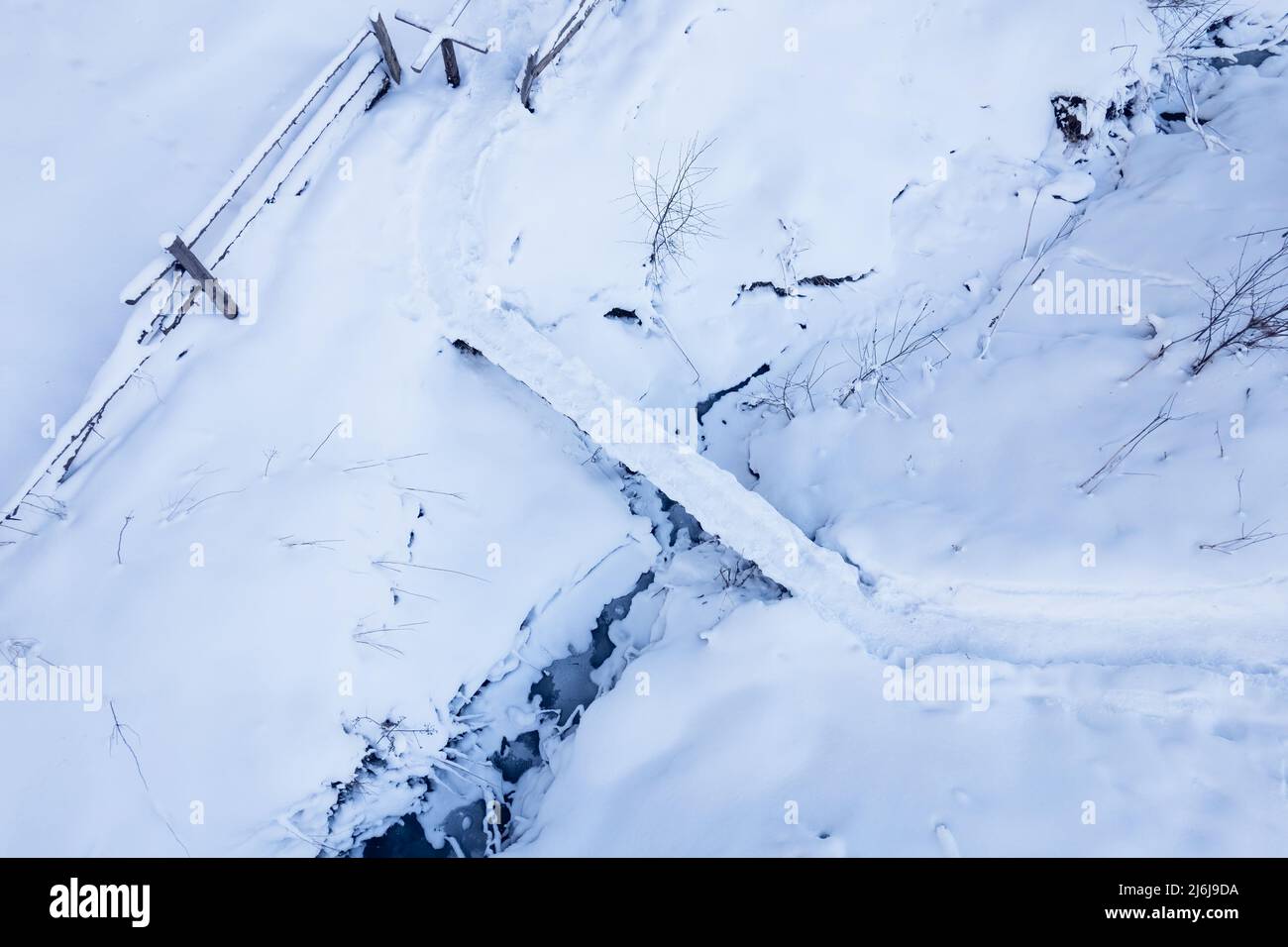 Brücke über einen Bach in einer Winterwiese. Stockfoto