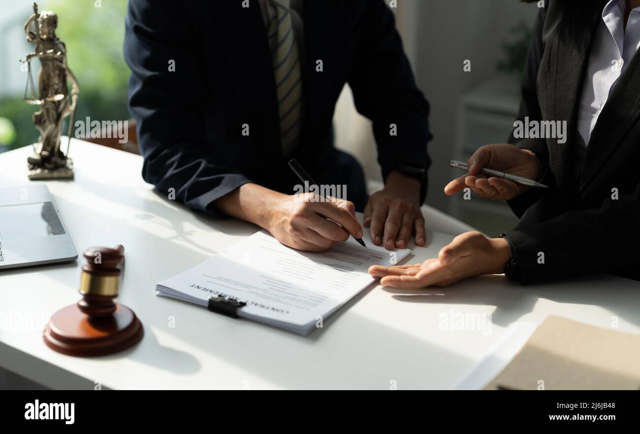 Rechtsberater präsentiert auf dem Client einen unterzeichneten Vertrag mit Hammer und rechtlichen Gesetz. Justiz und Rechtsanwalt Konzept. Stockfoto