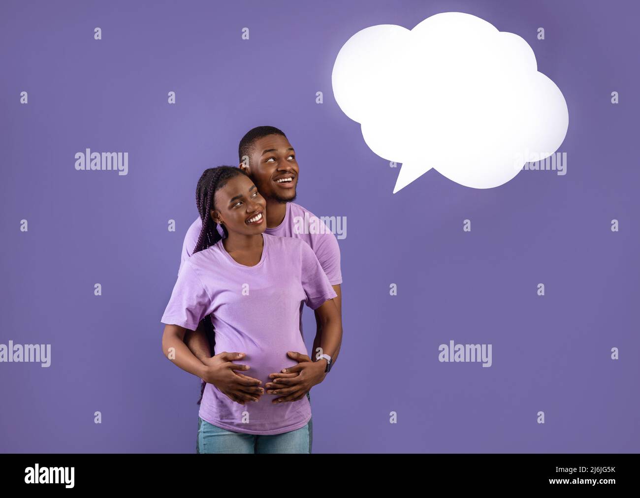 Lächelnder schwarzer Mann umarmt Schwangere, weiße Sprechblase Stockfoto