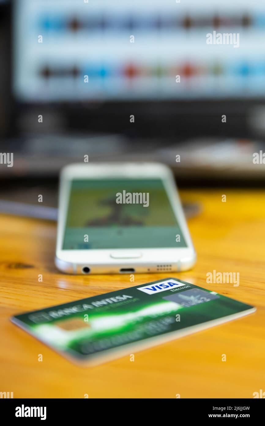 Belgrad, Serbien - April 15 2022 : VISA-Kreditkarte auf dem Tisch mit Smartphone und Laptop im Hintergrund. Fokus auf VISA-Logo Stockfoto