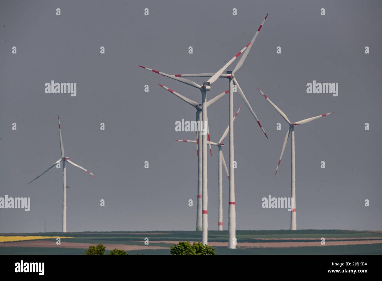 02. Mai 2022, Rheinland-Pfalz, Göllheim: Windräder sind hinter einer Landstraße zu sehen. Entlang der Autobahn A63 gibt es mehrere Windenergieanlagen. Foto: Boris Roessler/dpa Stockfoto
