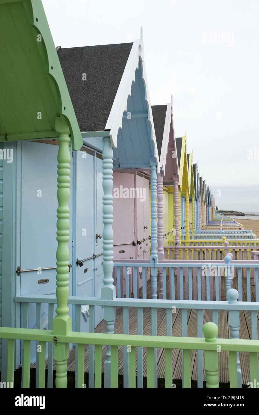 Bunt bemalte Strandhütten in einer Reihe in West Mersea, Mersea Island, Essex, Großbritannien Stockfoto