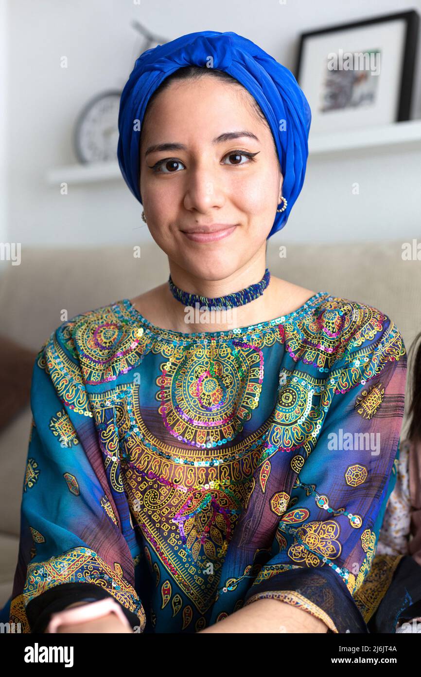 Porträt einer jungen muslimischen Frau zu Hause. Sie trägt ein für ihre Kultur repräsentatives Kleid und einen Turban. Stockfoto