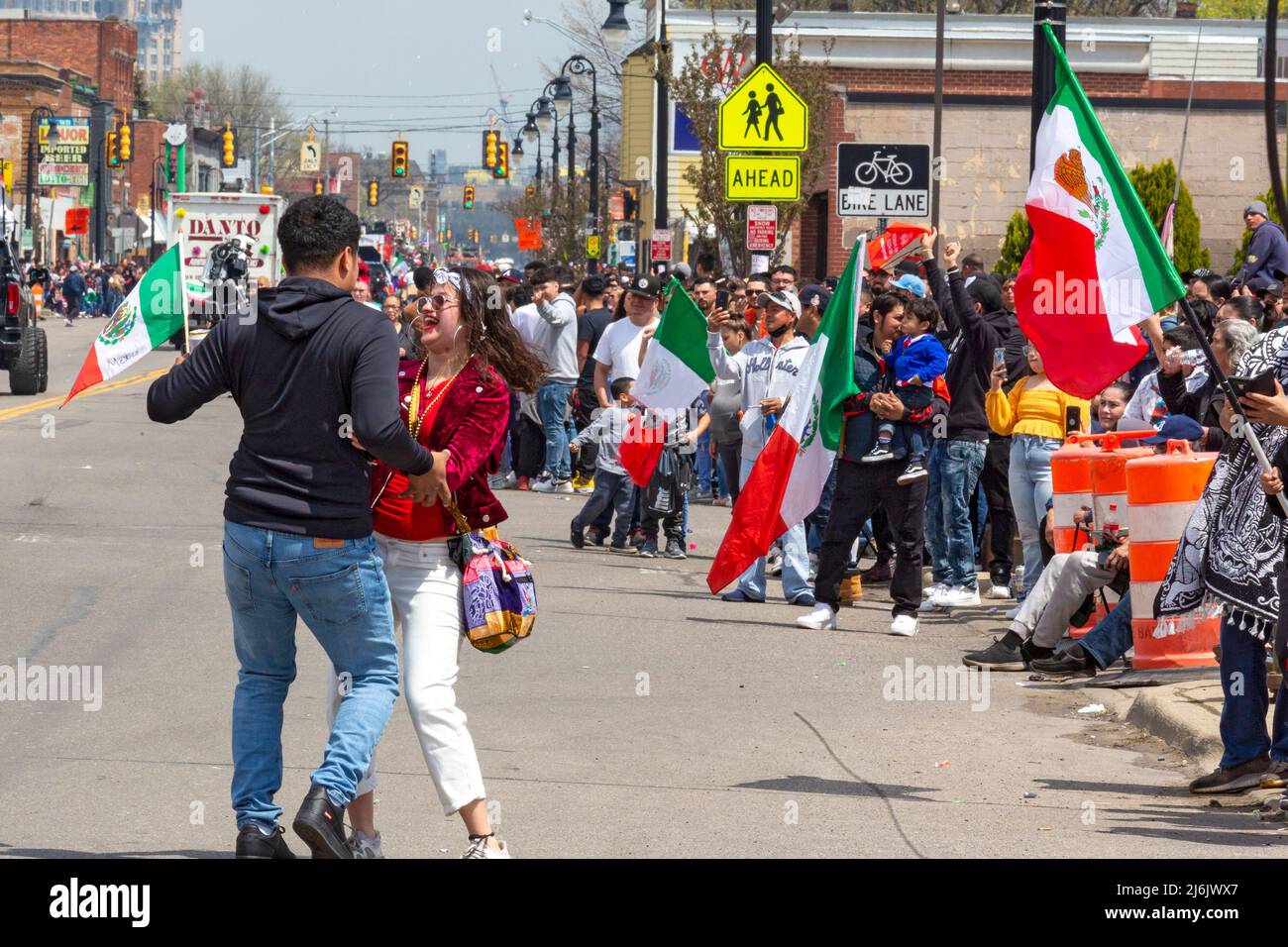 Detroit, Michigan USA - 1. Mai 2022 - Ein Paar tanzt auf der Straße, während Tausende den Vernor Highway säumten, um die Cinco de Mayo Parade in Detroits mexikanisch-amerikanischem Viertel zu beobachten. Die jährliche Parade kehrte 2022 nach einer zweijährigen Pause aufgrund der Pandemie zurück. Cinco de Mayo feiert am 5. Mai 1862 einen mexikanischen Sieg über die Franzosen. Kredit: Jim West/Alamy Live Nachrichten Stockfoto