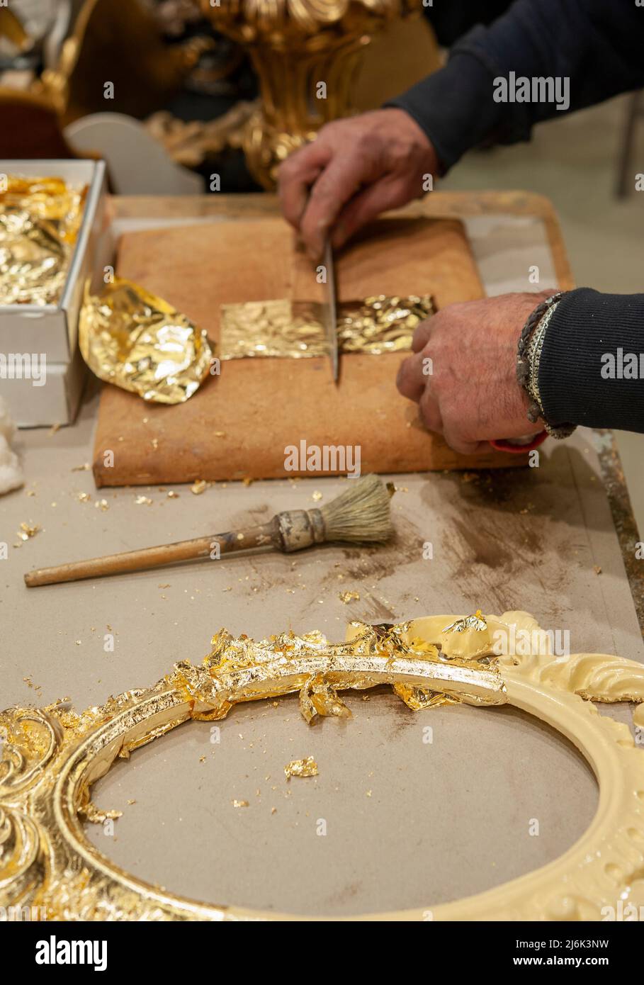 Anwendung von Blattgold auf einen Rahmen. Vergoldungsverfahren. Stockfoto
