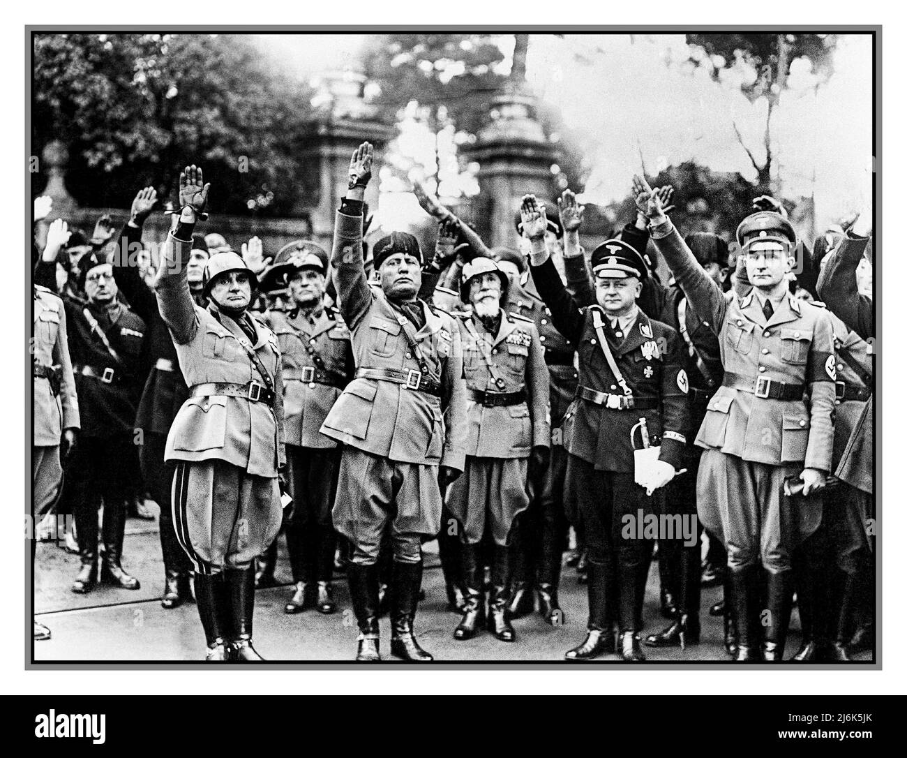 FACIST & NAZI-GRÜSSE 28. Oktober 1936 Benito Mussolini, zweiter von links, flankiert von Nazi-Offizieren anlässlich der Feier des vierzehnten Jahrestages des italienischen Faschismus, während eines Besuchs in Nazi-Deutschland Stockfoto