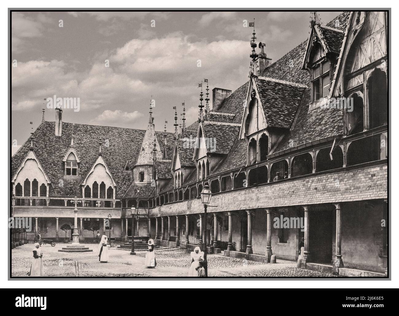 Beaune Vintage 1880er Jahre Retro Hospices de Beaune Courtyard des Krankenhauses von Beaune Hopital Beaune B&W Burgundy Cote d'Or Frankreich. Das Hospices de Beaune oder Hôtel-Dieu de Beaune ist eine ehemalige karitative Almshouse in Beaune, Frankreich. Es wurde 1443 von Nicolas Rolin, dem Kanzler von Burgund, als Krankenhaus für die Armen gegründet. Das ursprüngliche Krankenhausgebäude, das Hôtel-Dieu, eines der schönsten Beispiele der burgundischen Architektur aus dem 15. Jahrhundert, ist heute ein Museum. In modernen Krankenhausgebäuden werden Patientendienste angeboten. Stockfoto