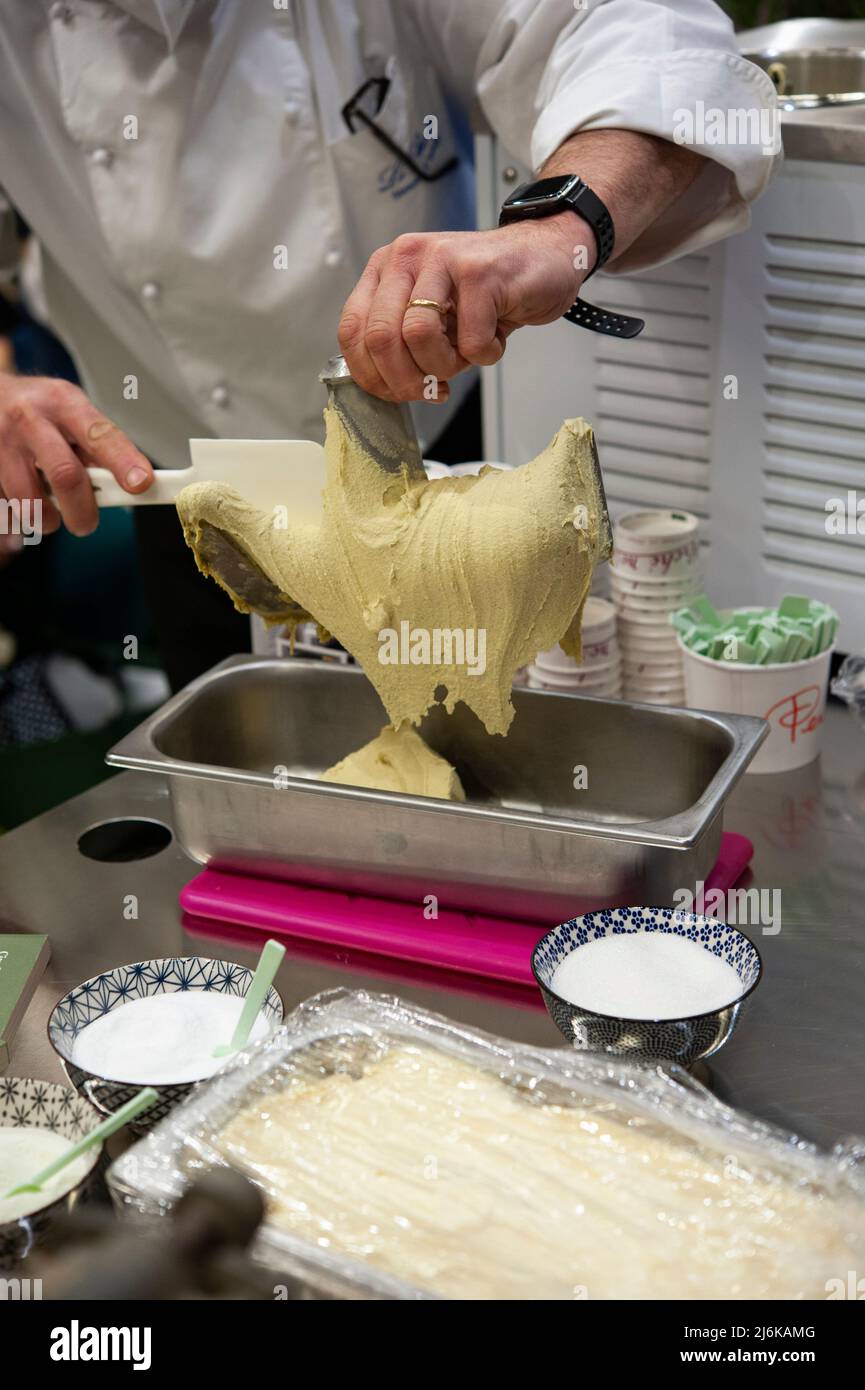 Eismann, während der Pistazien-Eiscreme-Zubereitung. Koch bei der Arbeit. Stockfoto