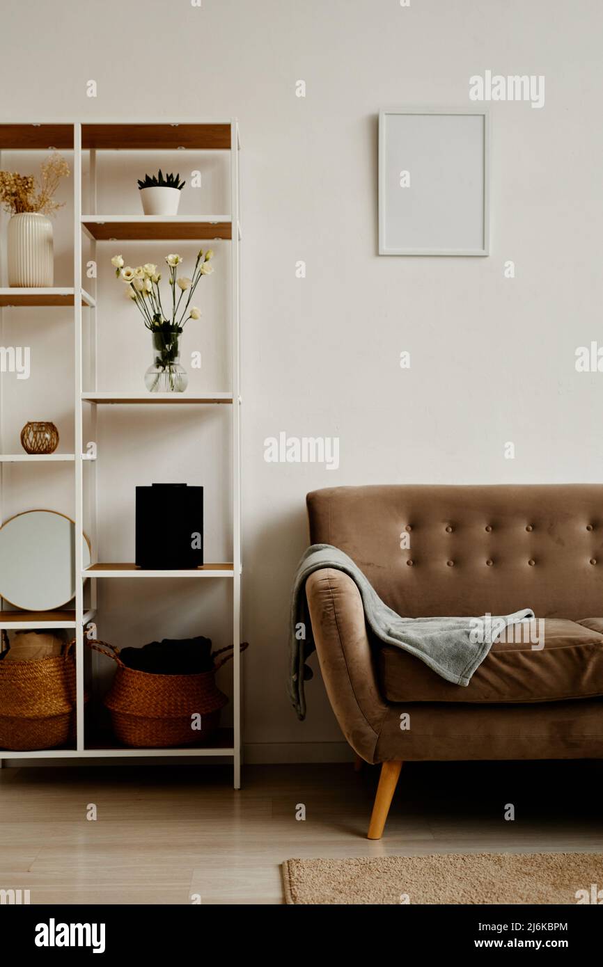 Vertikales Hintergrundbild der minimalen Wohnzimmereinrichtung mit gemütlicher Samtcouch und elegantem Dekor Stockfoto