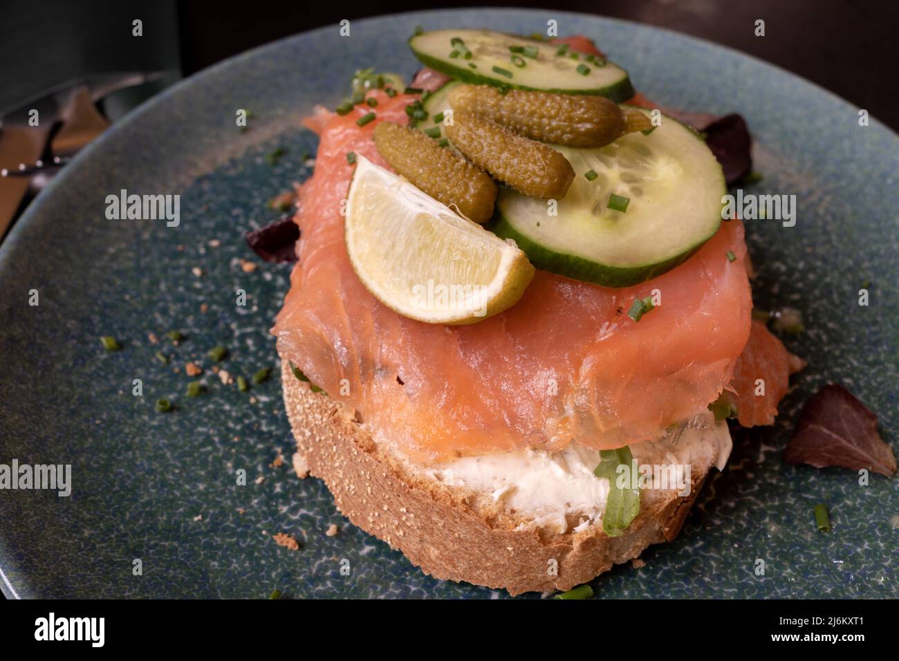 Europäisches Frühstück, Brotscheibe mit Rauchlachs, Frischkäse und Gurke. Stockfoto