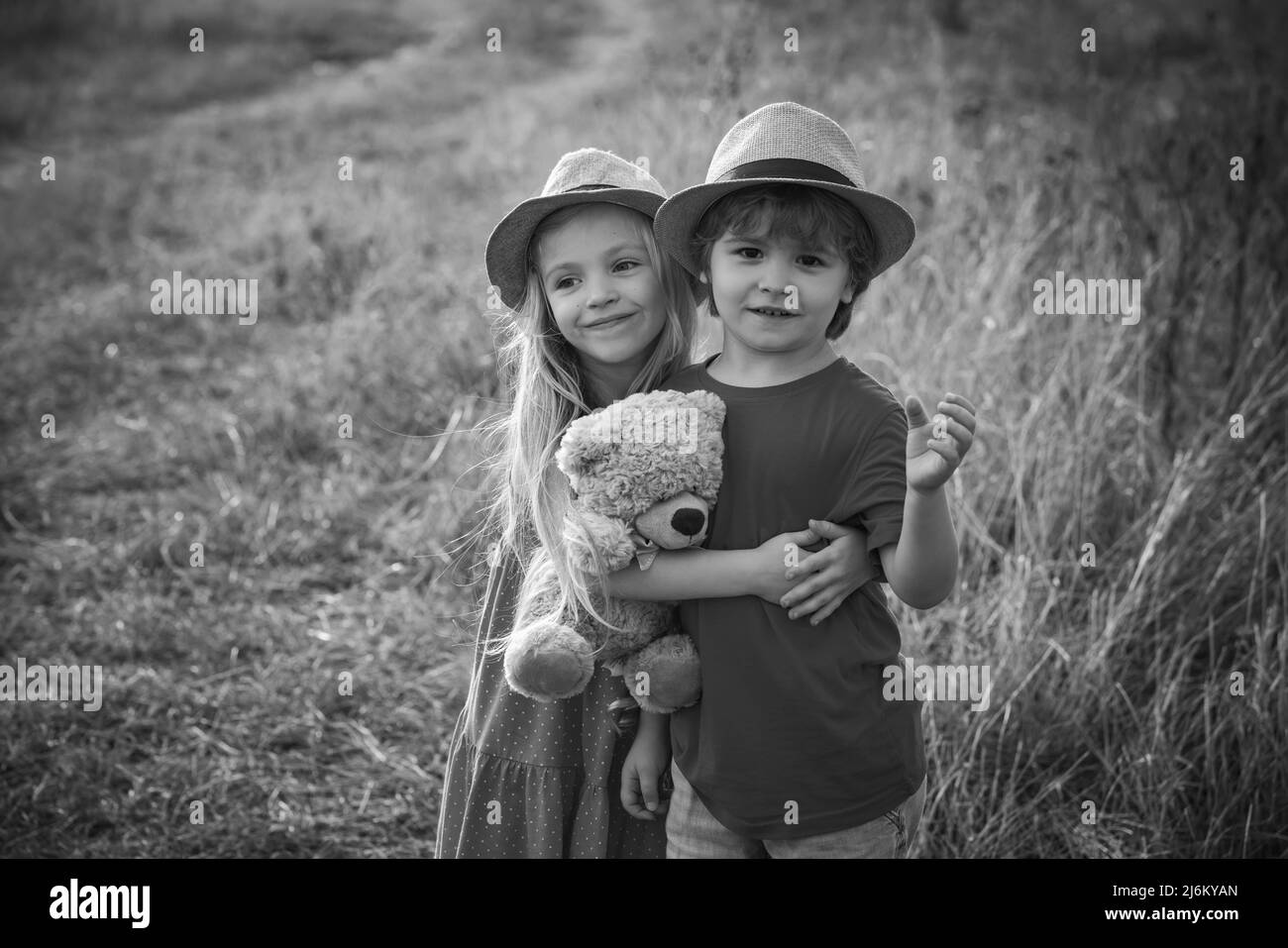 Kinder, die Spaß im Feld vor Natur Hintergrund. Glückliche Kinder Mädchen und Junge Umarmung auf Wiese im Sommer in der Natur. Schöne Kinder. Valentinstag Stockfoto