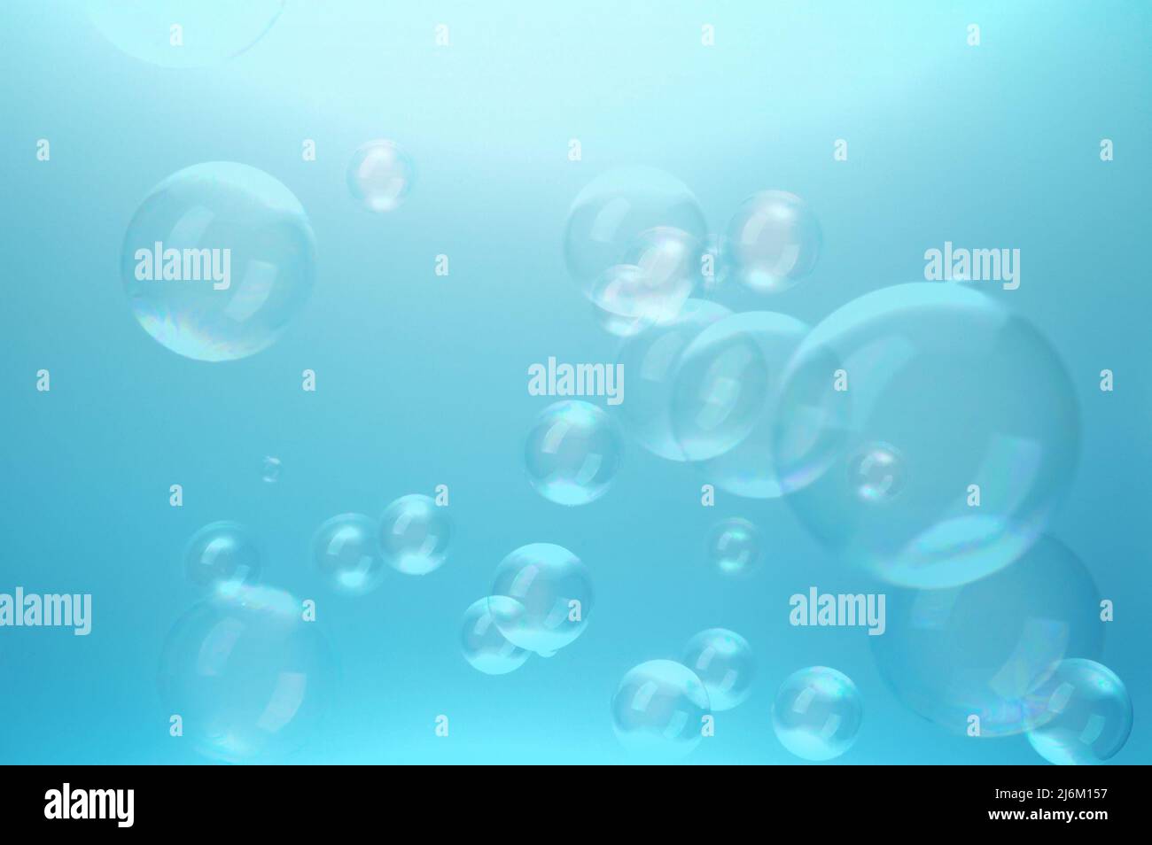 Blaue Blasen, schwebend in der Luft, blauer Hintergrund Stockfoto