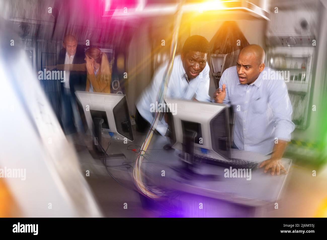 Männer in Angst auf der Suche nach einer Lösung auf dem Computer im Quest-Raum Stockfoto