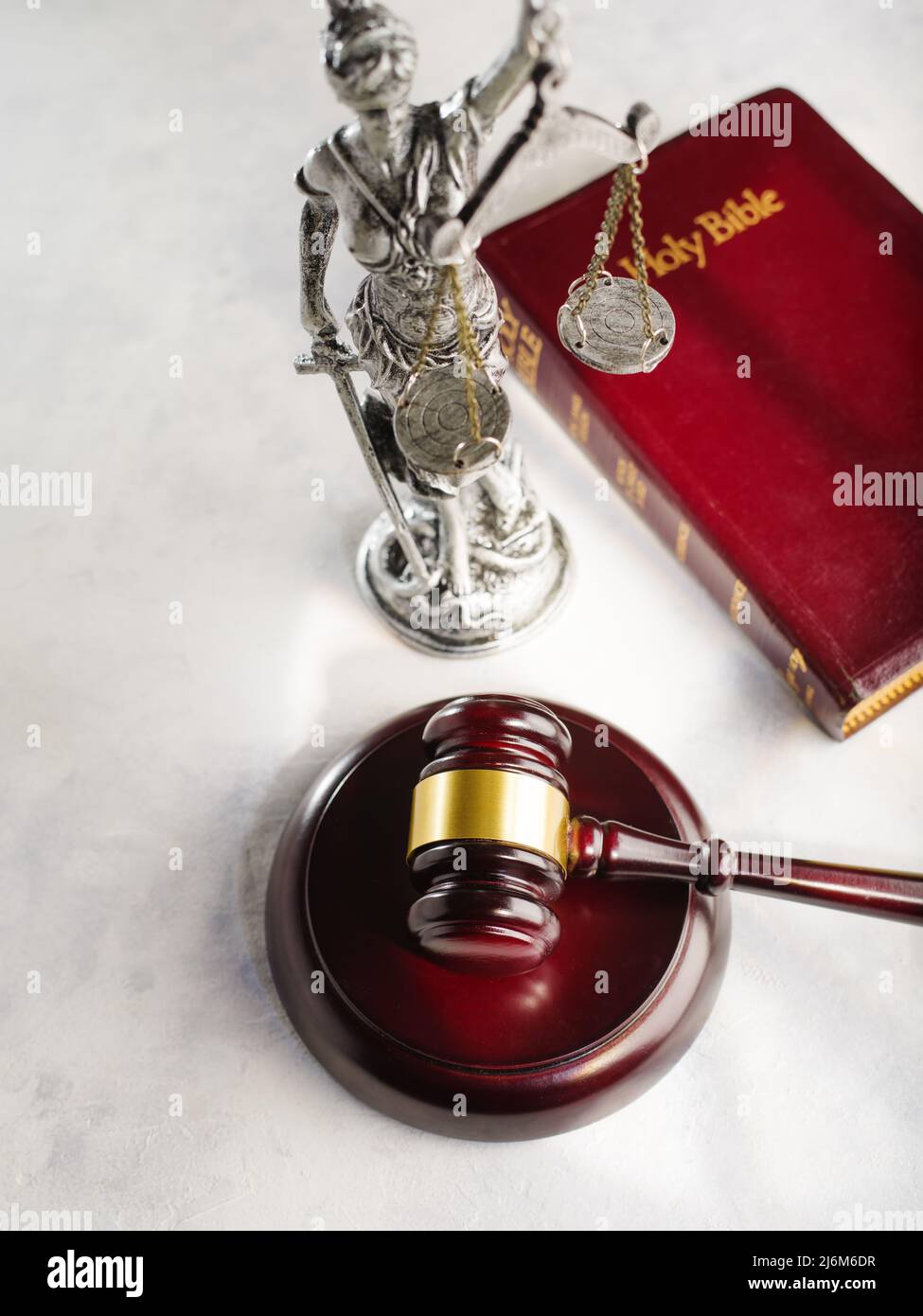 Der Gavel des Richters, die Heilige Bibel, die Figur von Themis - der Göttin der Gerechtigkeit auf weißem Hintergrund. Demokratie, Freiheit, Justiz, Fürsprache Stockfoto