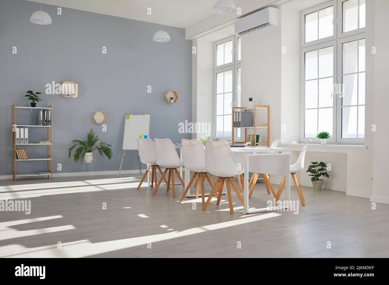 Leeres Büro mit Konferenztisch, Stühlen, Whiteboard, Regalen und Innenpflanzen Stockfoto