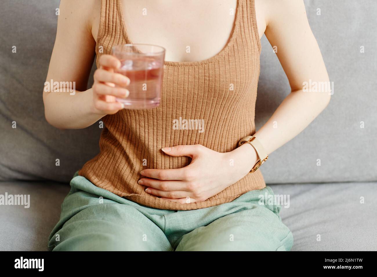 Nahaufnahme einer jungen Frau, die an Periodenkrämpfen leidet und die Hand auf dem Bauch hält, Raum kopieren Stockfoto