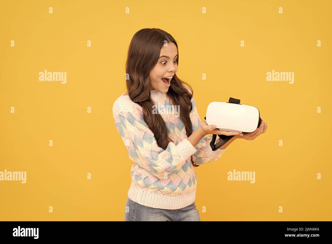 Moderne drahtlose Technologie. Kindheitsentwicklung. Stauned teen girl halten drahtlose VR-Brille. Stockfoto