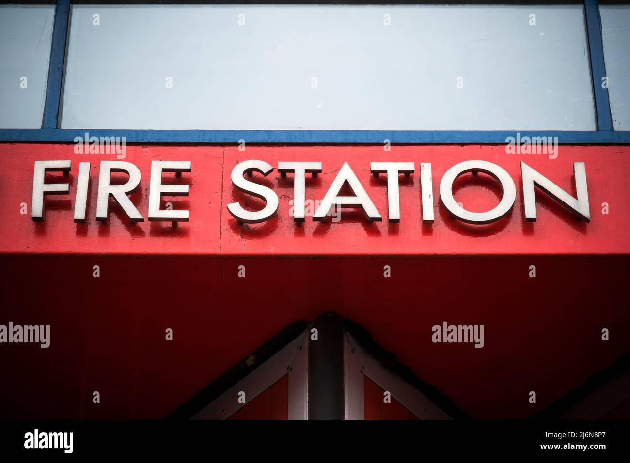Feuerwehr-Metallschild vor hellrotem Hintergrund Stockfoto