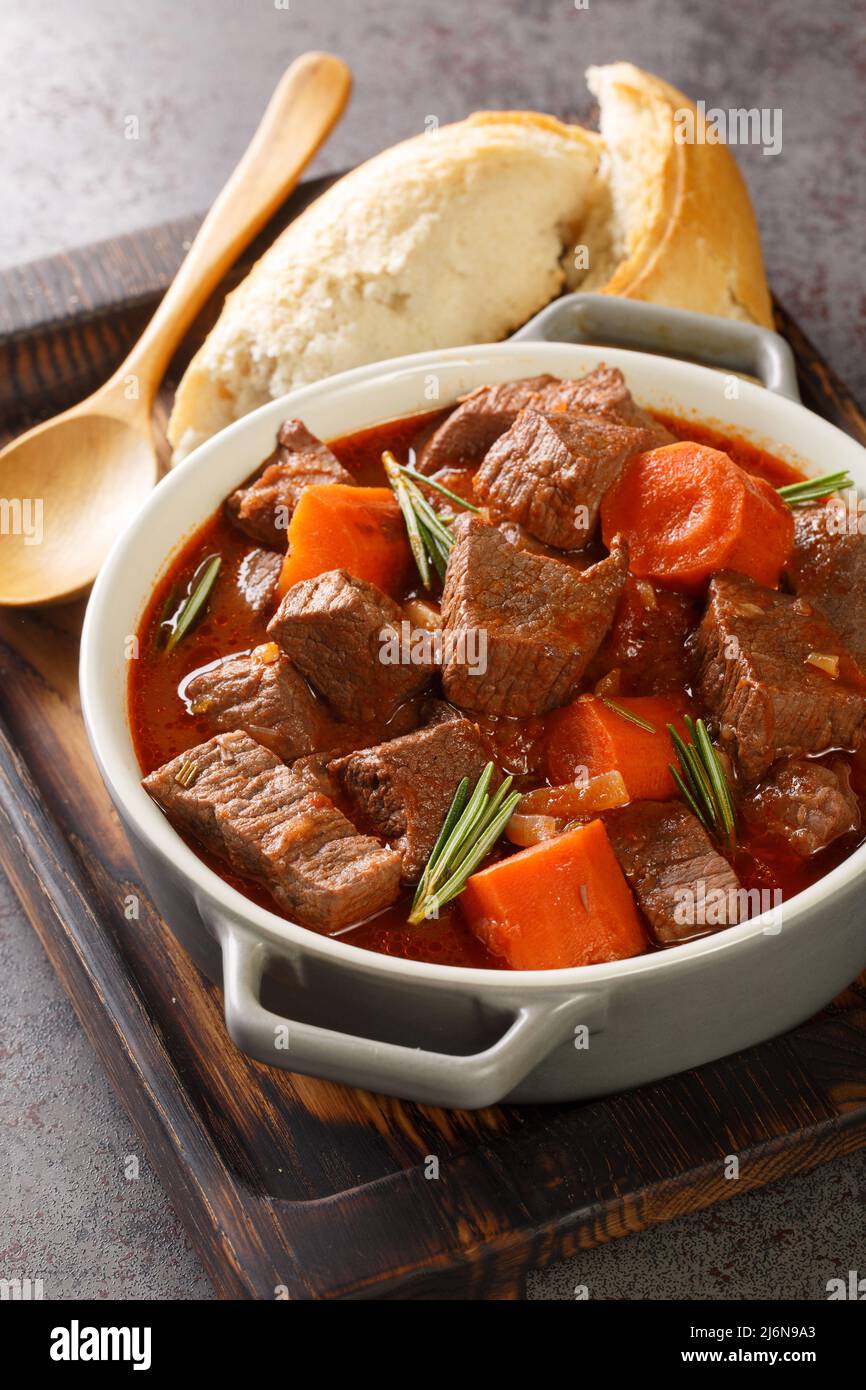 Daube provenzalischer Rotwein aus geschmortem französischem Rindfleisch und Gemüseeintopf aus der Nähe in der Holzschale auf dem Tisch. Vertikal Stockfoto