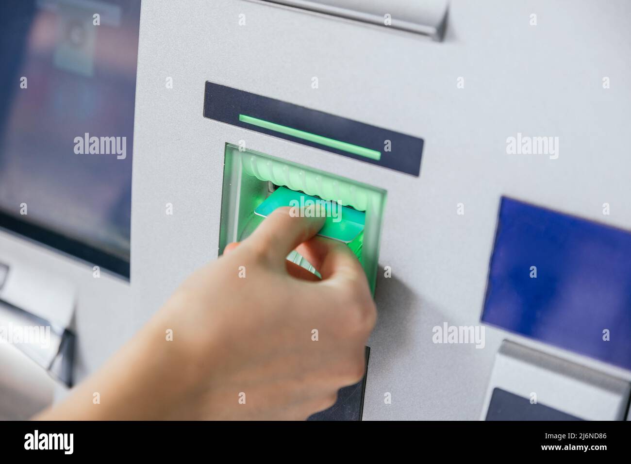 Frau, die eine Kreditkarte in den Geldautomaten einsteckt, um Geld zu überweisen oder abzuheben. Konzept der Finanzkunden- und Bankdienstleistungen Stockfoto