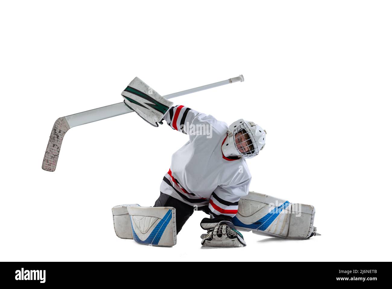 Porträt eines Teenagers, Eishockeyspielers, Torwarts, der Plug-in-Bewegung auf weißem Studiohintergrund abfängt Stockfoto