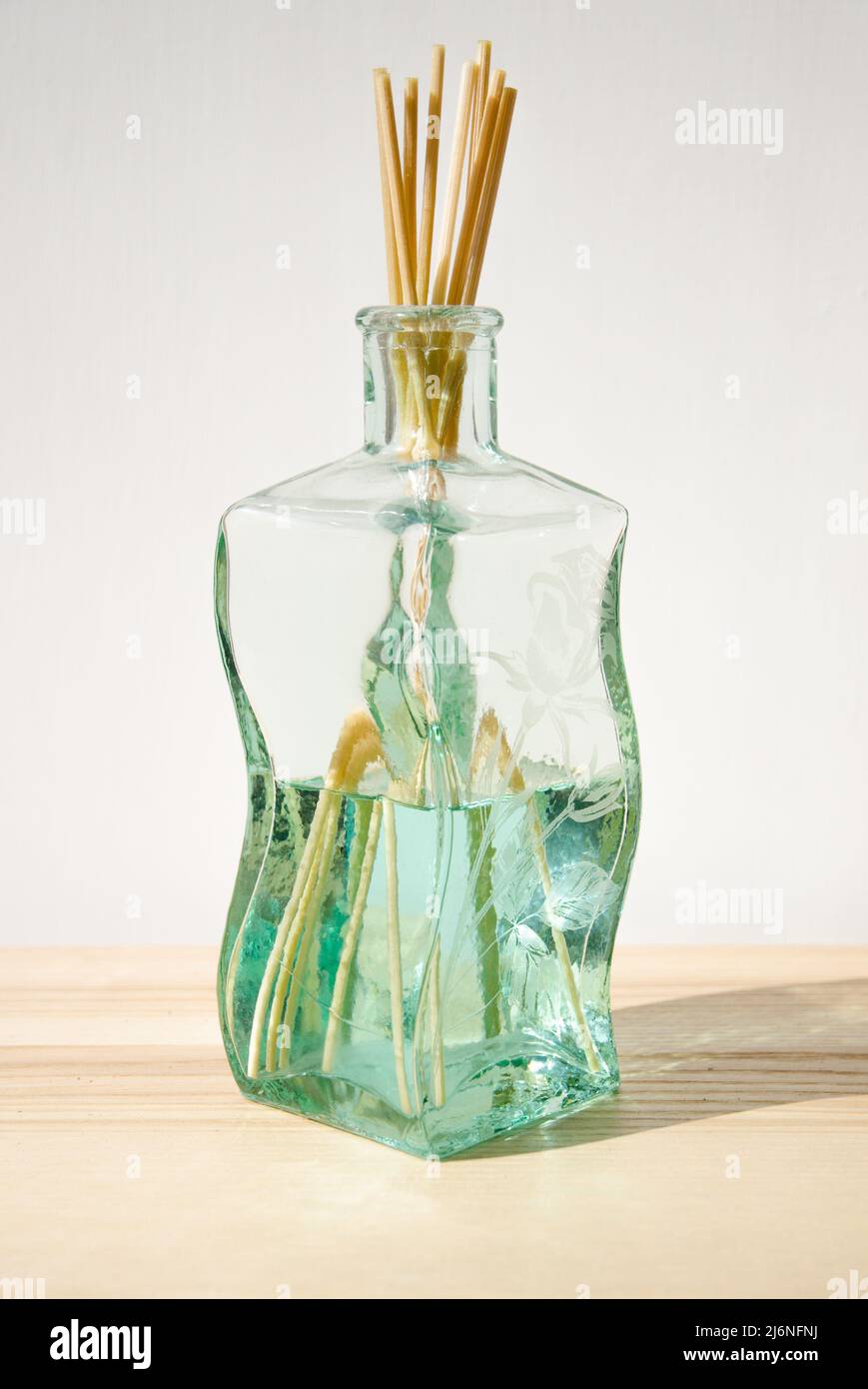 Glasflasche mit Raumduft und Bambusdiffusorstäben Stockfoto
