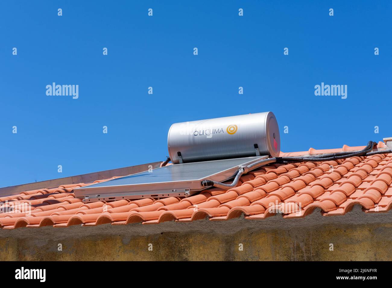 Castelo Branco, Portugal - Mai 01 2022: Solarwarmwasserbereiter OLICLIMA auf einem roten Ziegeldach in Portugal Stockfoto