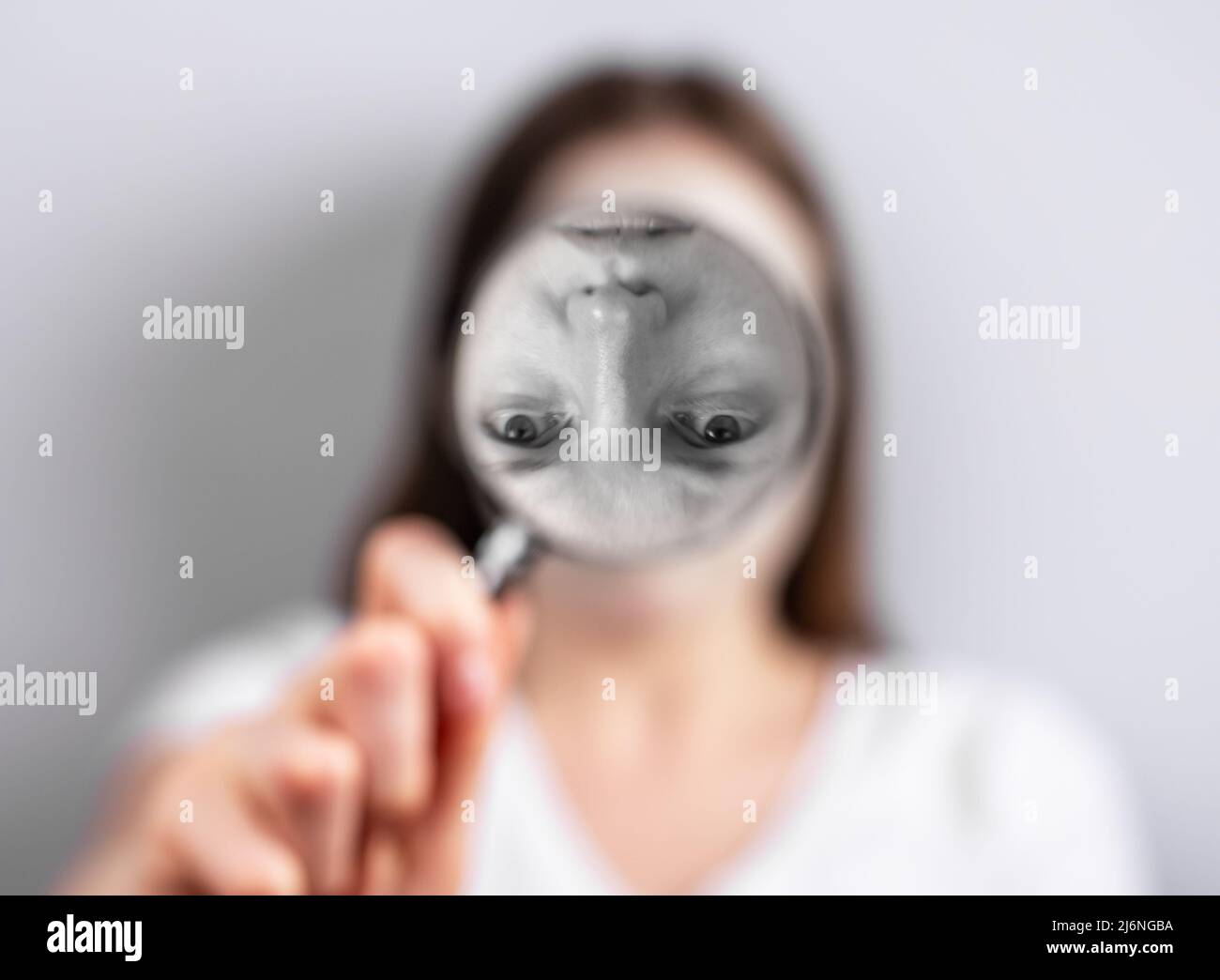 Verzerrte Selbstwahrnehmung oder Bildkonzept. Frau Gesicht auf Lupe umgedreht. Psychologische Probleme und ein schlechtes, instabiles Gefühl, wer du bist. Hochwertige Fotos Stockfoto
