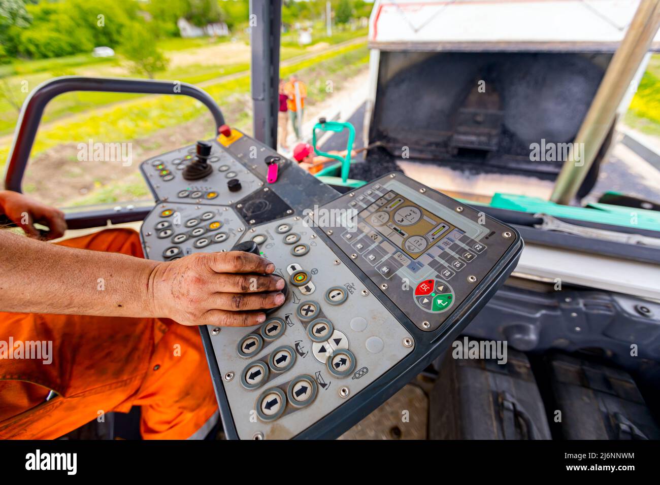 Arbeiter, Fahrer steuert Asphalt Straße Verlegemaschine mit Lenker, Joystick zu bedienen. Stockfoto