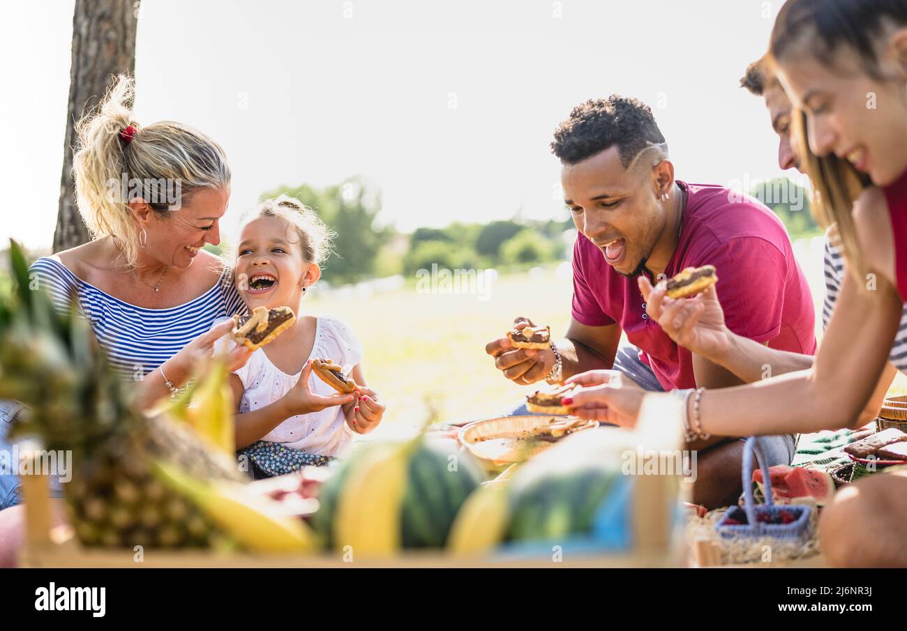 Beschnittene Ansicht von glücklichen multirassischen Familien, die Spaß mit Kindern auf pic nic Grillparty haben - multiethnisches Liebeskonzept mit gemischter Rasse Menschen, die Witz essen Stockfoto