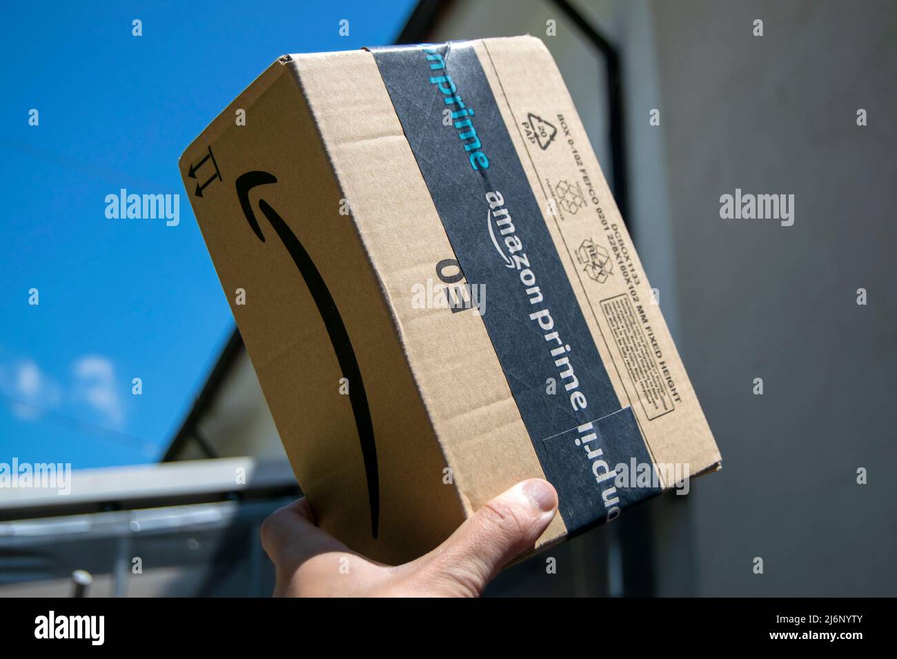 Amazon Prime schneller und erstklassiger Lieferservice. Amazon prime-Paket, Online-E-Commerce schnell und sicher. Lieferung Junge mit Amazon-Paket. Stockfoto