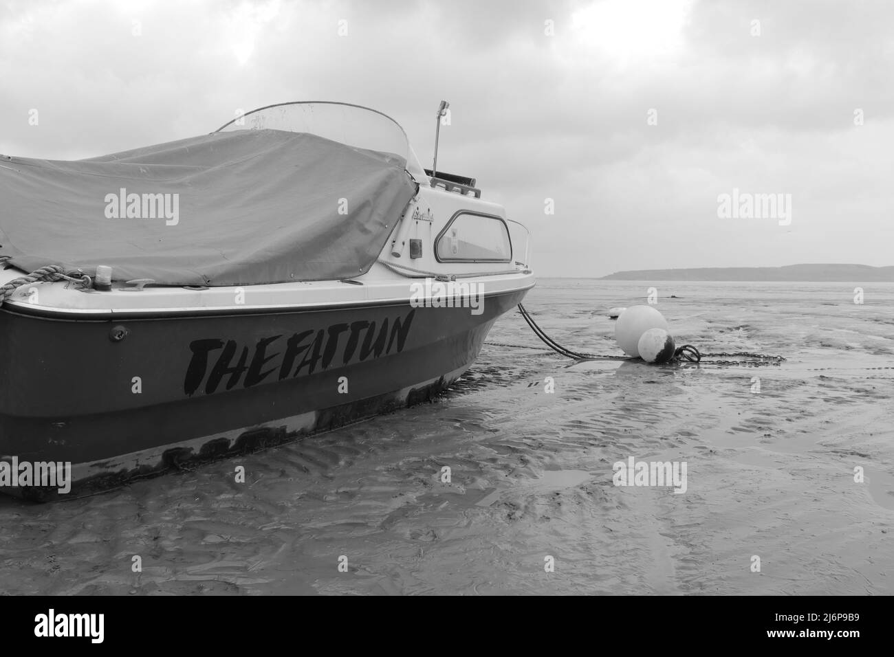 Eine monochrome Aufnahme eines Bootes, das im Schlamm stecken blieb Stockfoto