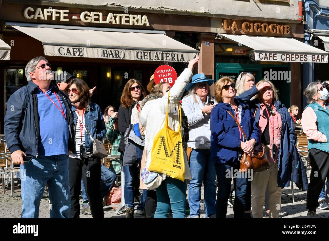 Straßburg, Frankreich - April 2022: Reiseführer in der Stadt, der einer Gruppe von Touristen von einer Wikinger-Flusskreuzfahrt etwas Interessantes zeigt Stockfoto