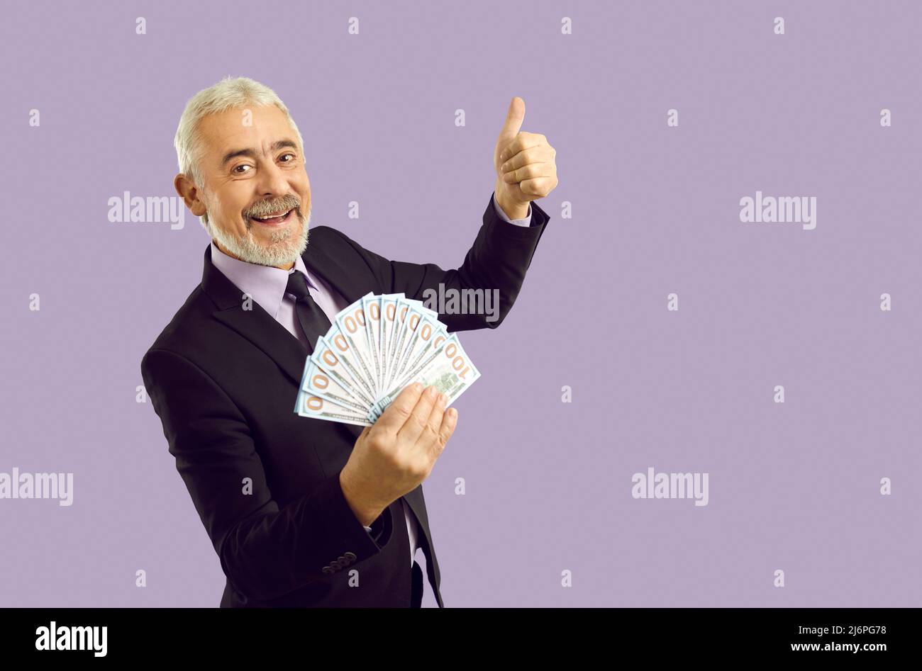 Lächelnder, gealterter Geschäftsmann mit Dollars in den Händen Stockfoto