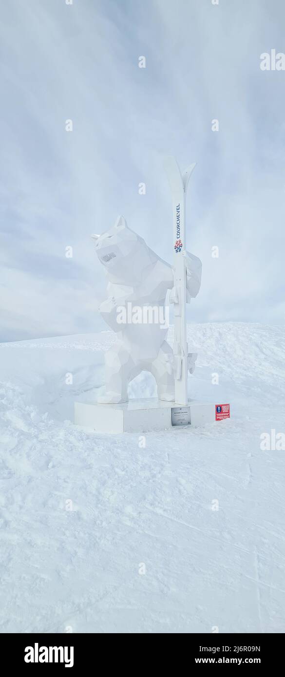 Courchevel, Frankreich - Februar 3 2022: Weiße Bärenskulptur mit Skiern in der Bärenpfote des Skigebiets in Courchevel 'Les Trois Vallees' auf Französisch Stockfoto