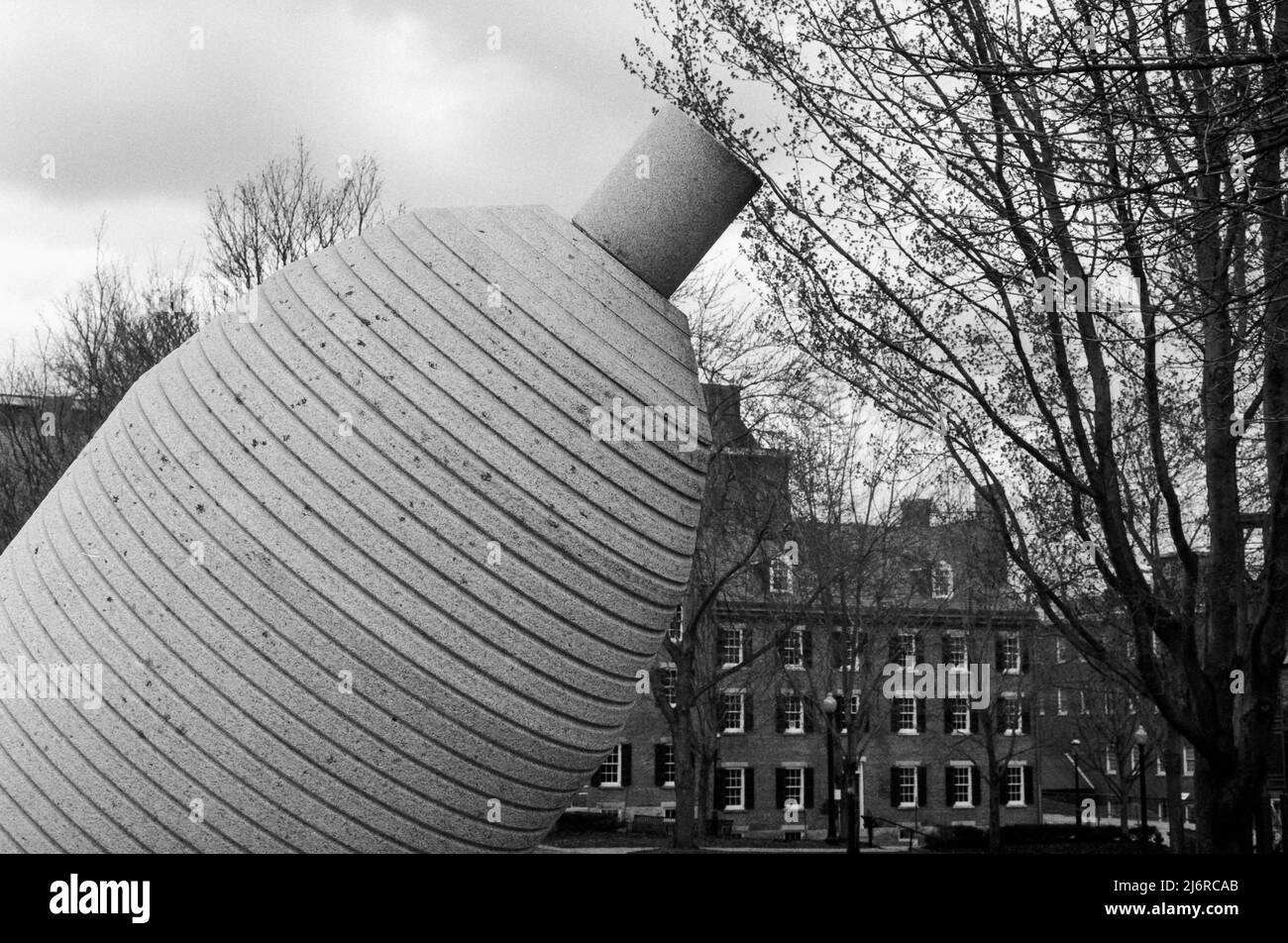 Eine Skulptur einer gekippten Mammutfadenspule, die von Robert Cummings im Boarding House Park Lowell, Massachusetts, auf einer Granitbasis montiert wurde. Erfasst auf einem Stockfoto