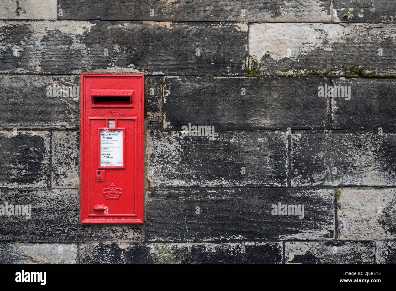 Traditioneller roter Briefkasten an einer Wand auf der Regent Terrace, Edinburgh, Schottland, Großbritannien. Stockfoto