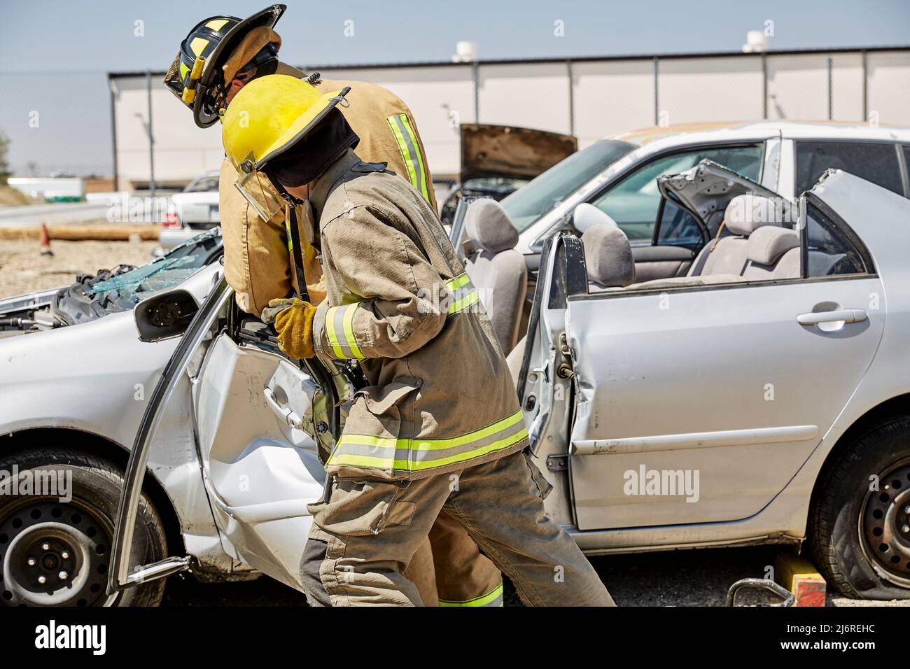 Feuerwehrleute, die eine Autotür entfernen Stockfoto