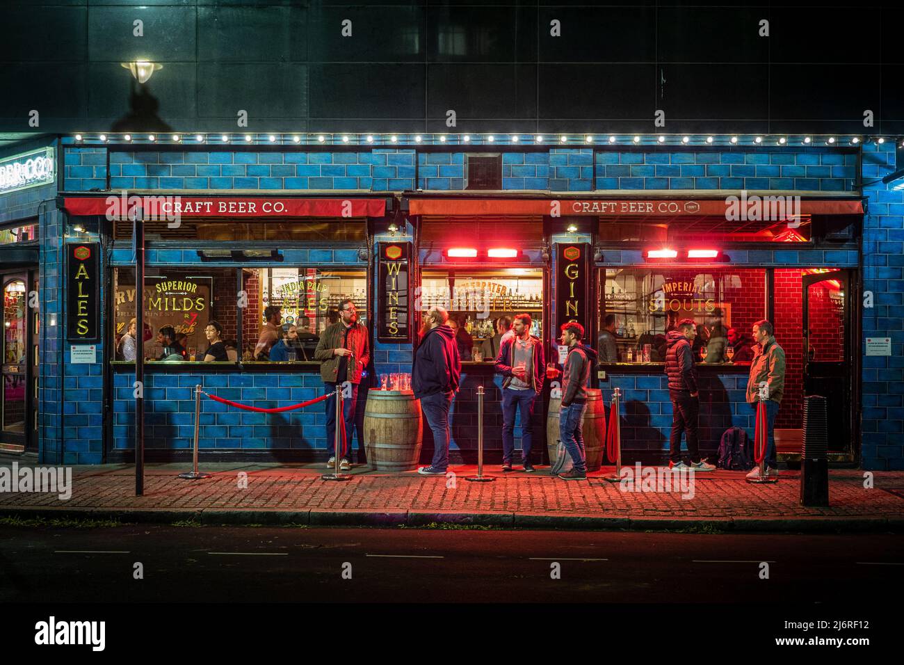 Nachts gibt es eine belebte Bar im Freien in London, wunderschön beleuchtet Stockfoto