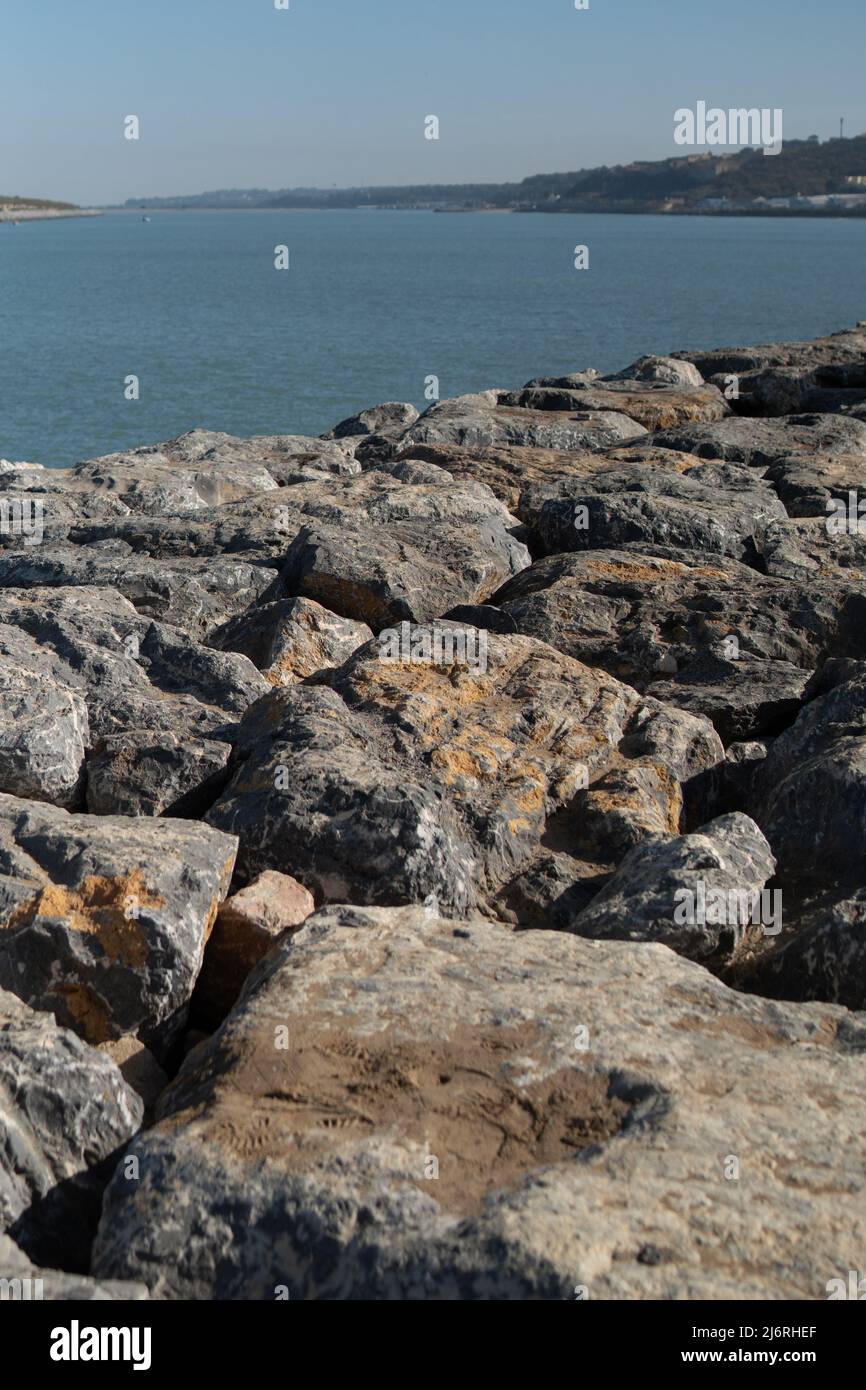 Das Meer rockt gegen den blauen, klaren Himmel Stockfoto