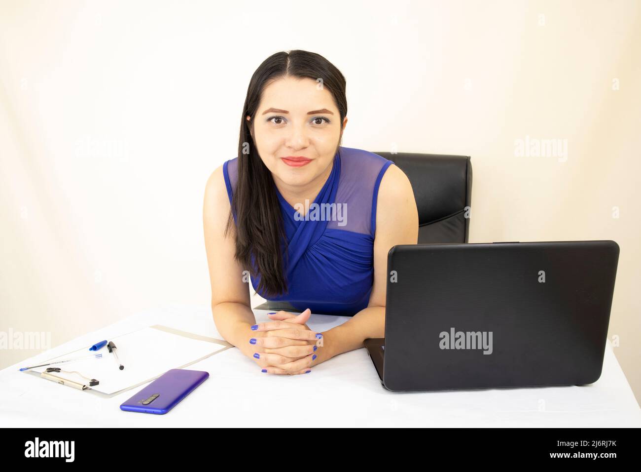 Nette erfolgreiche CEO-Assistentin in blauer Bluse, glücklich über ihre Arbeit, Schreibtisch mit Dokumenten und Laptop, Szene auf weißem Hintergrund Stockfoto