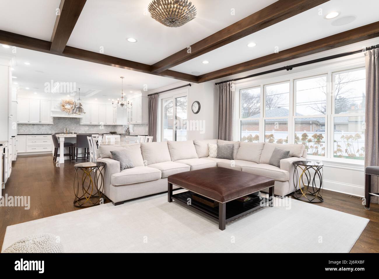 Ein luxuriöses Haus mit Blick auf ein Wohnzimmer, Esszimmer und eine große weiße Küche. Stockfoto