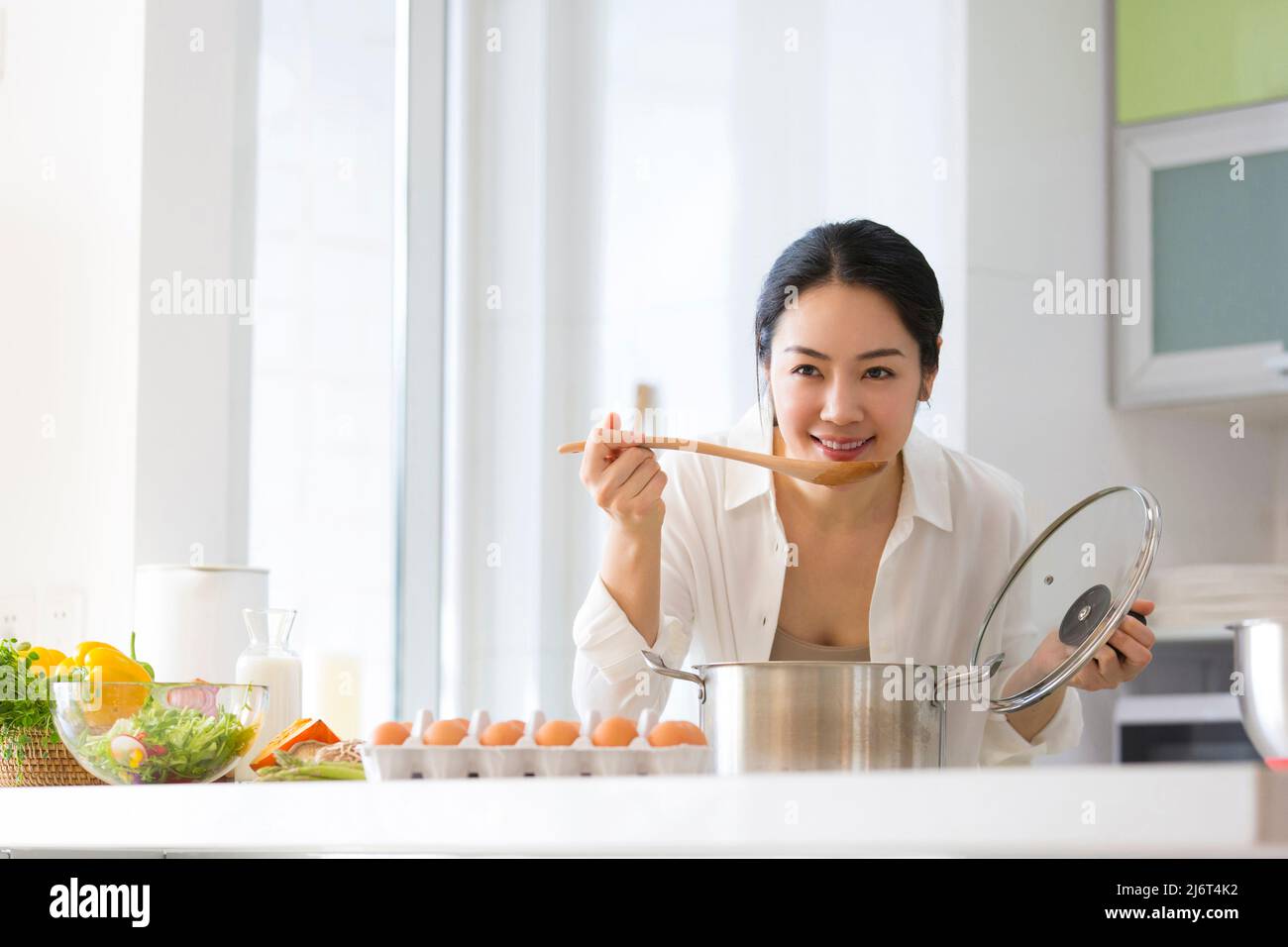 Junge Hausfrau Verkostung Essen in der Küche - Stock Foto Stockfoto